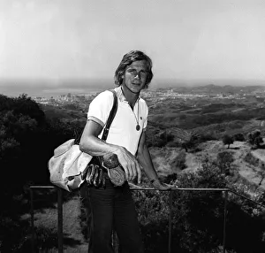 Motor racing driver James hunt on holiday in Spain 1975 with his golf clubs