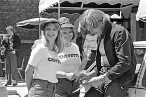 Stewardesses Prints: Motor Racing Driver James Hunt signs his autograph for two of his female stewardesses