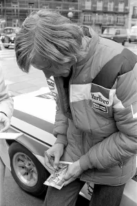 00930 Prints: Motor Racing Driver James Hunt signs his autograph on a photograph of himself