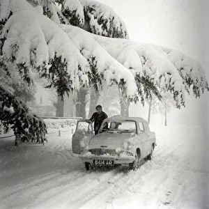 00617 Prints: A motorist clears the snow off his car after a heavy fall in Hadley Wood