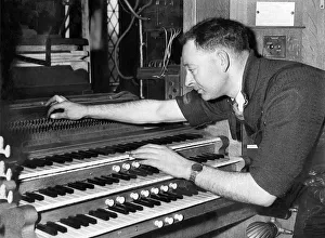 Mr. H. E. Prested test the action of an organ after re-assembly in May 1957