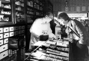 00083 Prints: Mr. James Taylor maintaining essential services by emergency lighting in a pharmacy