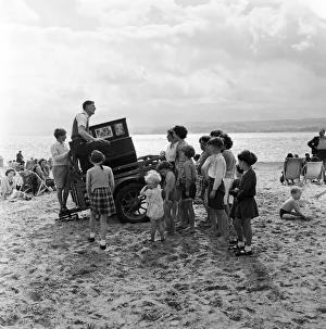 Deckchairs Prints: Mr Percy Tucker playing an ancient Barrel Organ on the beach of Exmouth
