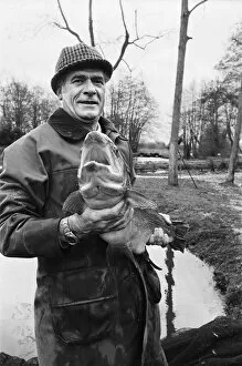 Images Dated 18th March 1977: Mr Sam Holland (52) owner of Avington Trout Fishery, with a 3 year old Avington Strain