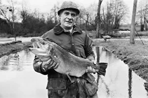 Images Dated 18th March 1977: Mr Sam Holland (52) owner of Avington Trout Fishery, with a 3 year old Avington Strain