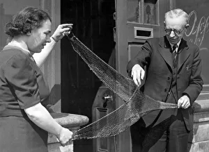 00091 Prints: Mr. W. Fraser, stores manager at Irvins North Shields with a moedl trawl net in 1949