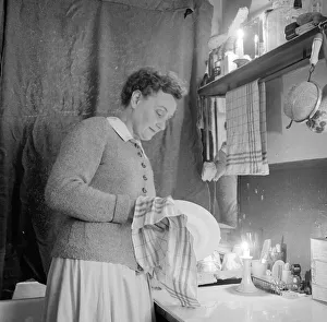 Household Prints: Mrs Dorothy Mead who still lights her house with gas lamps Seen here washing up by