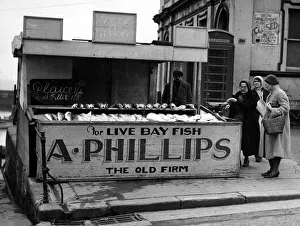 00170 Prints: Mrs Phillips serving customers at her stall in Princes Street, Bridnlington