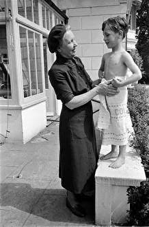 00017 Prints: Mrs Stewart of the W. V. S. acts as godmother to a child at the Hollyshaw Nursery