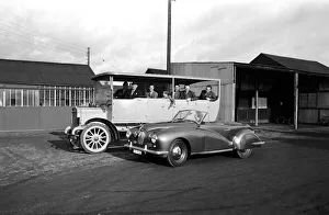 Mrs. W. A. Hudson seen here passing a vintage coach in her new sports car