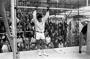 Muhammad Ali in a cage protected by glass from hundreds of fans who paid 50p to watch him