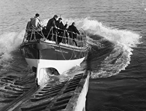 Craft Prints: The Mumbles lifeboat plunges down from the slipway as she leaves to deliver Christmas