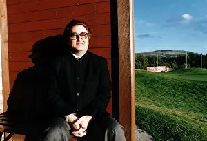 Music - Singer and songwriter Gerry Rafferty entertainer sitting brown fence green field