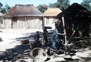 African Prints: native woman pounding manioc in luando at the game reserve in central Angola