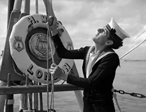 00007 Prints: A naval rating raising the white ensign aboard the County Class cruiser HMS London which