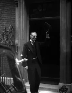 Neville Chamberlain Prime Minister outside 10 Downing Street raises his hat to