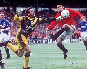 00403 Prints: Neville Southall Football goalkeeper for Everton FC bending down to pick up the football