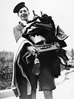 A new entrant of HMS Arthur carries an armful of kit including two pairs of boots
