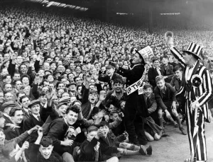 Cheering Prints: Newcastle mascot Jimmy Nichol leads the cheers of the Newcastle crowd before the game