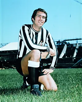 Kneeling Prints: Newcastle United Bob Moncur poses on the pitch at St James as construction of the new