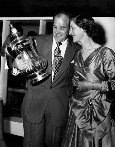 Newcastle United captain Jimmy Scoular shows off the FA Cup trophy to his wife after his