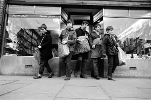 Newspaper round boys leaving the newsagents with their newspapers, ready for delivery