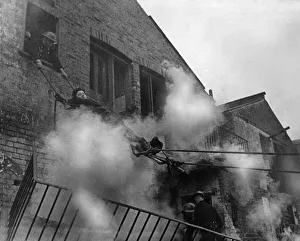 01437 Prints: NFS Task division training exercise on lowering casualty from an upper floor of a bombed