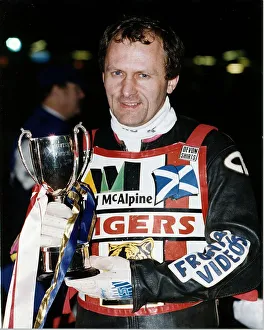 Nigel Crabtree stands holding the Phonesport KO Cup motorcycling speedway outdoors night