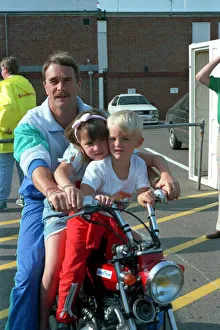 Motor Sports Prints: NIGEL MANSELL AND CHILDREN CHLOE MANSELL AND GREG MANSELL ON A BIKE AT THE FORMULA 1