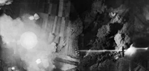 Night time aerial view showing bomb damage to a depot of tanks