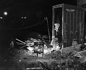 Night Watchman keeps himself warm by a brazier whilst guarding road works in Eastleigh