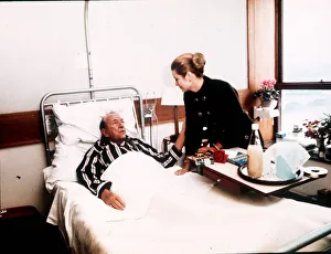 Patient Prints: Noel Coward lying in hospital bed visited by Princess Grace of Monaco in St Thomas