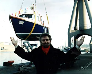 Noel Edmonds TV Presenter at launch of boat Pride of Inverkeith in sling above dock