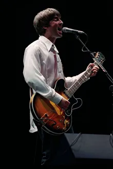 Noel Gallagher of the pop group Oasis on stage singing and playing guitar at Loch Lomond