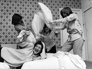 Nolan sisters Maureen flops on the bed under the combined assault of Anne, Left