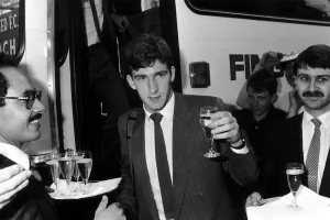 Ne022 Prints: Norman Whiteside of Manchester United raises a glass after getting of the team coach