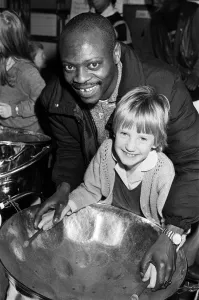 00586 Prints: North Star steel drummer Kelvin Benjamin helps Sarah Stead play the soprano drum during