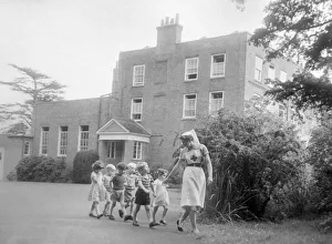 A nurse takses some children for a walk around the grounds of the Beech Hill House