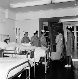 Nurses receiving instruction from Miss V Thomas (in surgical gown) on patient care