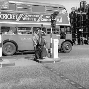 00068 Prints: Occupation: Busker: Johnny Hawksworth seen here busking with his Double Bass in Central