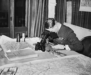 Reconnaissance Prints: An officer studies reconnaissance pictures taken over Germany at a Wing Headquarters of