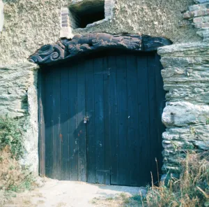 Wood Prints: The old figurehead from a ship used as a lintel over a barn door in Crantock, Cornwall