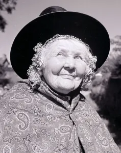 National Dress Prints: Old lady dressed in traditional clothes Paisley patterned shawl hat tied under chin