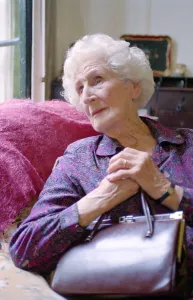 Old Lady looking into a holding her handbag Old Lady Sitting in A Chair