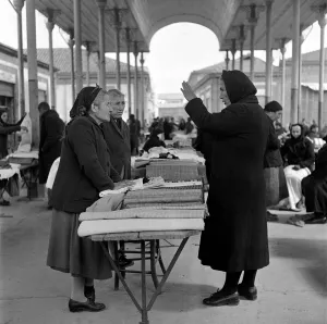 Old women bargaining for materials with vendors at a market in a Cyprus town