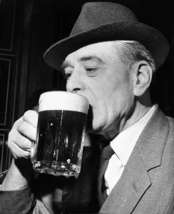 00067 Prints: An older gentleman enjoys a refreshing pint at his local pub April 1964
