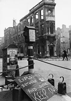 An ominous sign warning of live explosives displaying in a street during the Second World