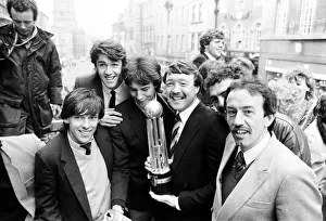 Oxford United footballers with the Second Division Championship trophy on an open top bus