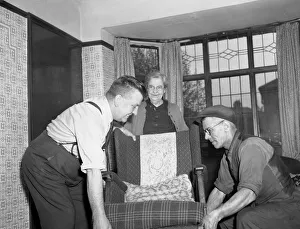 00089 Prints: Painters and decorators seen here removing the furniture before they start work as a