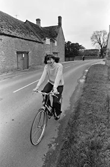 Pam Ayres riding her bicycle near her home in a village in Oxfordshire. 12th May 1977